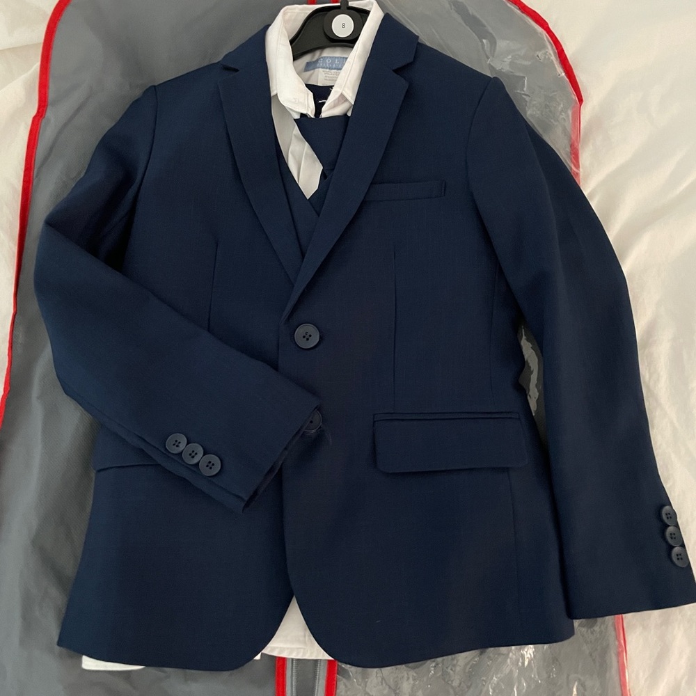 Navy suit for boys, size 8. Includes jacket, vest, tie, and pants and shirt.
